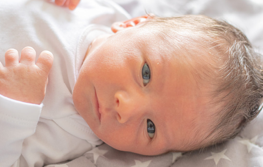 Petit enfant (nouveau né) qui regarde attentivement son papa ou sa maman. Cette photo illustre l'article sur le masque et l'enfant.