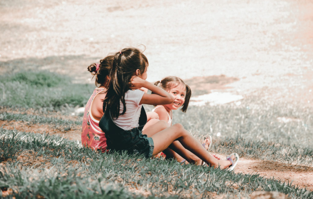 Groupe d'enfant qui partagent un bon moment sur l'herbe